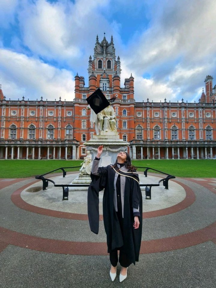 Rutba Damani in graduation gown outside Royal Holloway