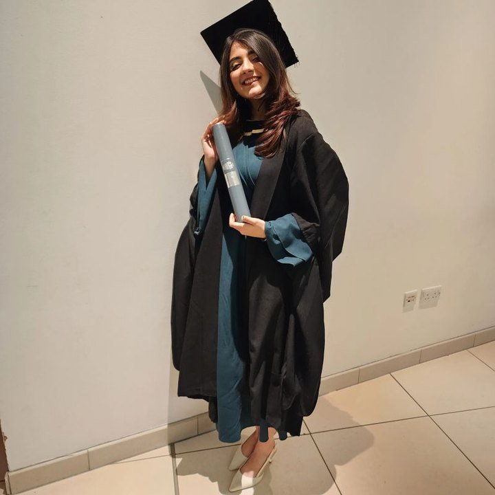Rutba Damani at graduation holding her diploma